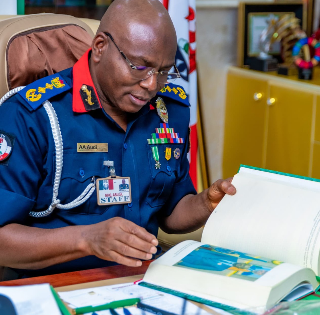 PEOPLE’S SECURITY MONITOR: The indefatigable Dr. Ahmed Abubakar Audi, Commandant General of the Nigeria Security and Civil Defence Corps, reading through his impressive 778-page 4th-year compendium of achievements shortly after it was presented to him by its author, Isiaka Mustapha, Editor-in-Chief/CEO of People’s Security Monitor, last week at the National Headquarters of the NSCDC in Abuja.”